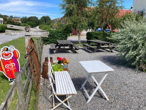 a fence with a picnic table and a table and chairs at Kustnära Vandrarhem in Hamburgsund