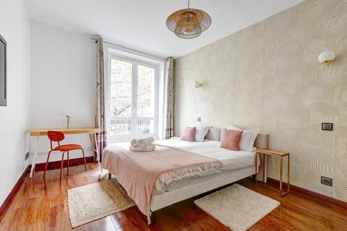 une chambre avec un lit, un bureau et une fenêtre dans l'établissement Martine Suite, Place de la République, à Paris
