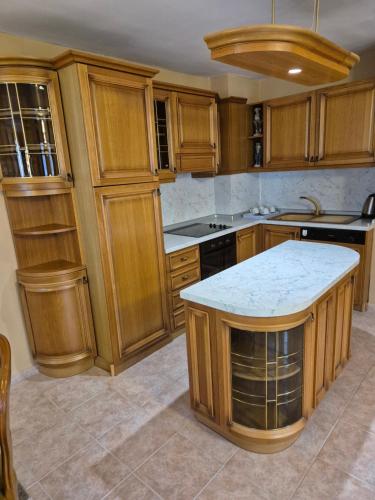 a kitchen with wooden cabinets and a white counter top at The White House in Nesebar