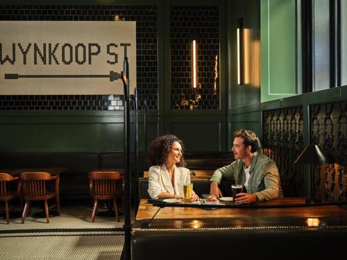 a man and woman sitting at a table in a restaurant at The Crawford Hotel in Denver
