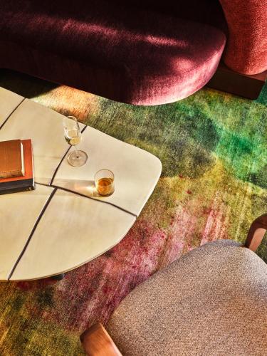 a table with a glass of wine on the floor at The Crawford Hotel in Denver