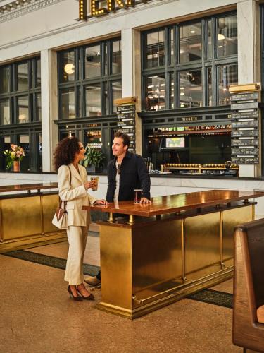 a man and a woman standing at a desk at The Crawford Hotel in Denver