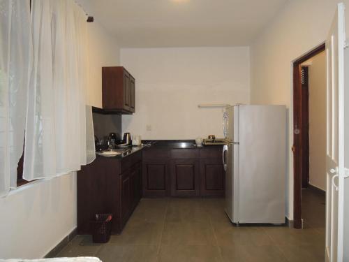 a kitchen with a white refrigerator and wooden cabinets at The Residence Bentota in Bentota