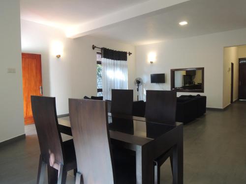 a dining table and chairs in a living room at The Residence Bentota in Bentota