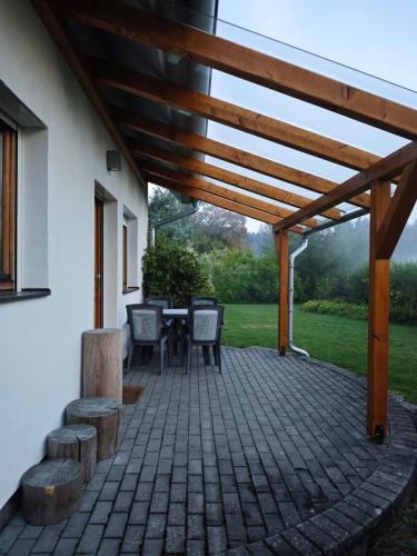 a patio with a table and chairs and a wooden pergola at Chata pro dva nebo pro celou rodinu in Slavníč