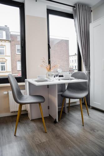 a desk and two chairs in a room with a window at Cozy and central Apartment Lübeck in Lübeck