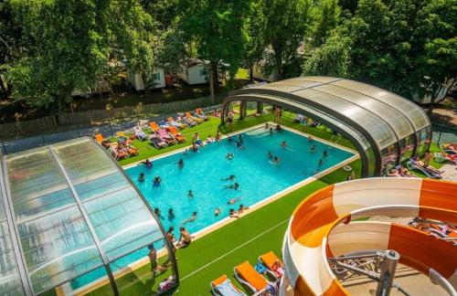 un groupe de personnes nageant dans une piscine dans l'établissement Camping - Parc aquatique - ccafhb0, à La Baule