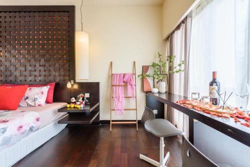 a bedroom with a bed and a desk and a table at Resort Suites at Pyramid Tower by GL Staycation in Petaling Jaya