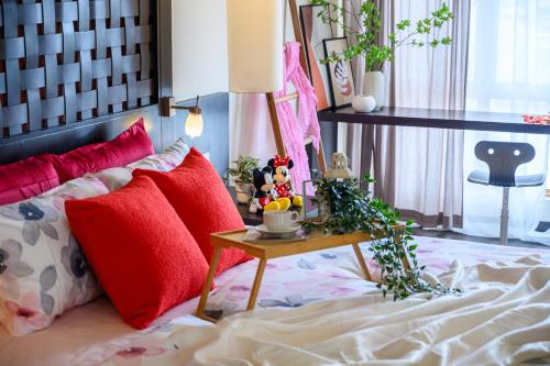 a bedroom with a bed with red pillows and a table at Resort Suites at Pyramid Tower by GL Staycation in Petaling Jaya