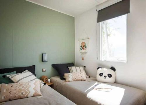 a bedroom with two beds and a window at ZEcamping familial dog friendly familial parc aquatique in Olonne-sur-Mer