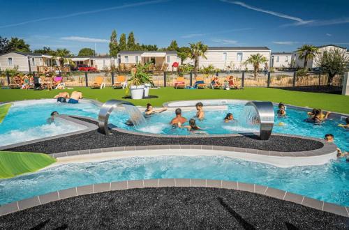 un groupe de personnes dans une piscine d'un complexe hôtelier dans l'établissement Camping - Parc aquatique - ccaggcd, à Olonne-sur-Mer