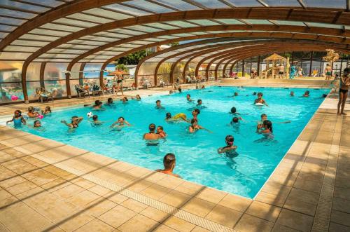 a group of people swimming in a swimming pool at ZEcamping animé dog friendly familial piscine couverte in Saint-Georges-dʼOléron