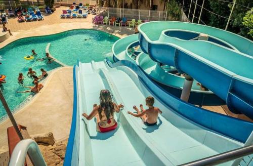 a group of people on a water slide at a swimming pool at ZEcamping familial espace aquatique pet friendly in Argelès-sur-Mer