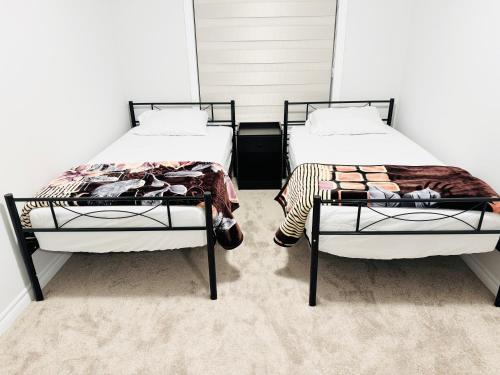 two beds sitting next to each other in a room at Best home in Oshawa in Oshawa