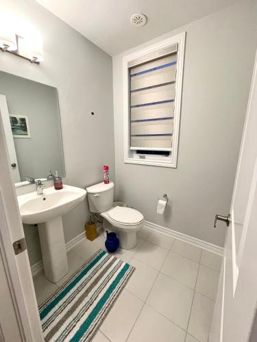 a bathroom with a sink and a toilet and a window at Best home in Oshawa in Oshawa