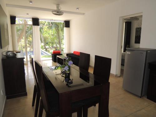 a living room with a dining room table with chairs at The Residence Bentota in Bentota