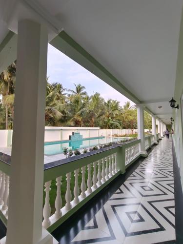 a balcony with a view of the beach and palm trees at Le French Nest in Puducherry