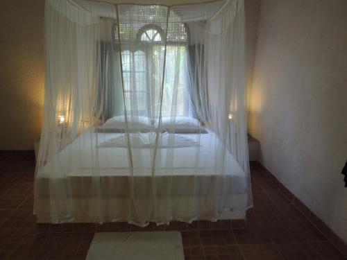 a bedroom with a canopy bed with a window at The Residence Bentota in Bentota