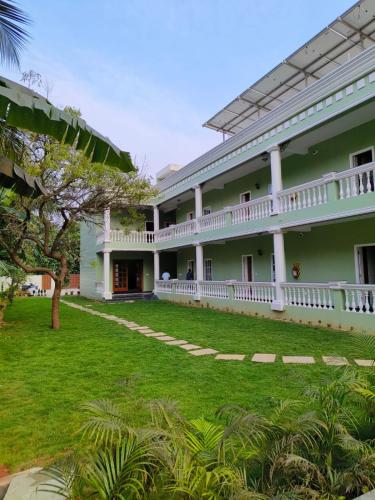 a large green building with a white balcony at Le French Nest in Puducherry
