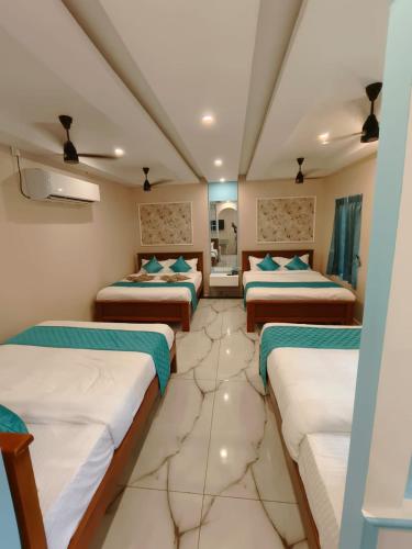 a room with four beds in a room at Le French Nest in Puducherry