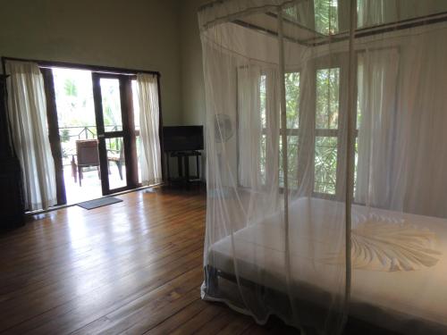 a bedroom with a canopy bed and a wooden floor at The Residence Bentota in Bentota