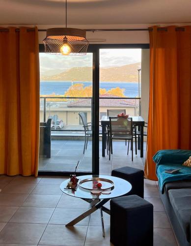 - un salon avec une table et une vue sur l'océan dans l'établissement Superbe T3 vue mer, à Propriano