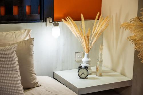 a table with a clock and a vase on a bed at Resort Suites at Pyramid Tower by GL Staycation in Petaling Jaya