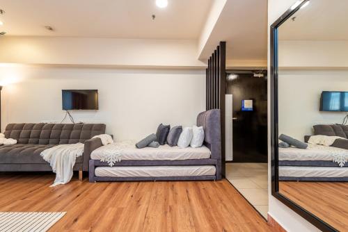 a living room with two couches and a mirror at Resort Suites at Pyramid Tower by GL Staycation in Petaling Jaya