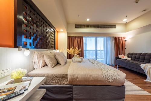 a bedroom with a large bed and a couch at Resort Suites at Pyramid Tower by GL Staycation in Petaling Jaya