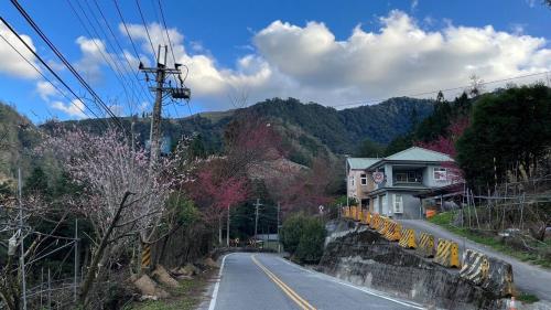 a road with a house on the side of a mountain at Lishan House in Heping