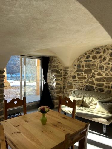 un salon avec une table en bois et un canapé dans l'établissement Risoul Village - Appartement 4 personnes - Le Languieu, à Risoul