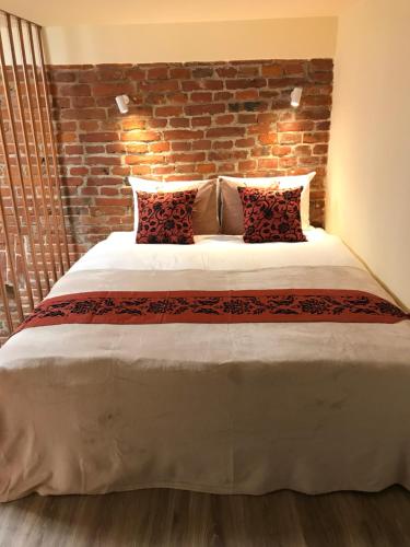 a bedroom with a large bed with a brick wall at Center Lviv Avenue 23 in Lviv