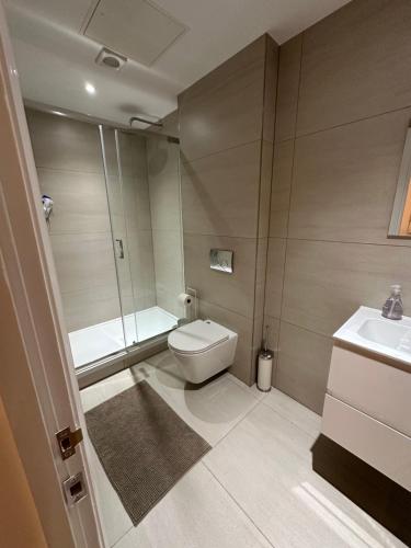 Un baño con inodoro, ducha y lavabo. en London Apartment West One, en Londres