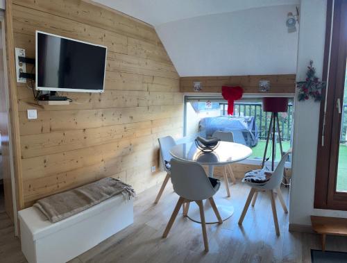 - un salon avec une table, des chaises et une télévision dans l'établissement T3 cosy et calme, Balcon, Parking, cœur du village, à Saint-Lary-Soulan