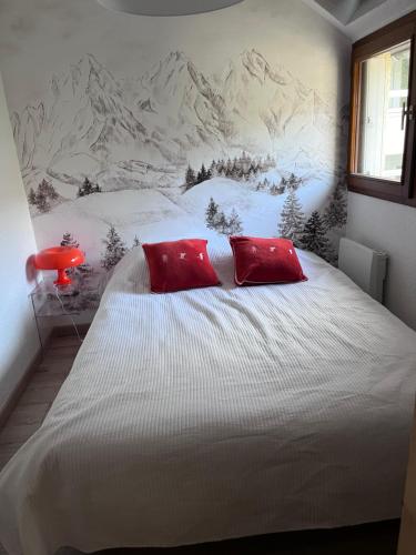 - un lit avec 2 oreillers rouges dans une chambre dans l'établissement T3 cosy et calme, Balcon, Parking, cœur du village, à Saint-Lary-Soulan
