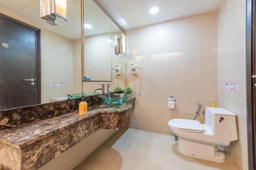 a bathroom with a sink and a toilet and a mirror at Resort Suites at Pyramid Tower by GL Staycation in Petaling Jaya
