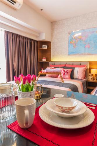 a room with two beds and a table with plates and flowers at Resort Suites at Pyramid Tower by GL Staycation in Petaling Jaya