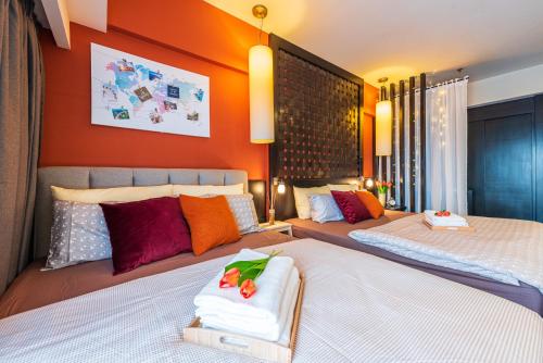 two beds in a bedroom with orange walls at Resort Suites at Pyramid Tower by GL Staycation in Petaling Jaya