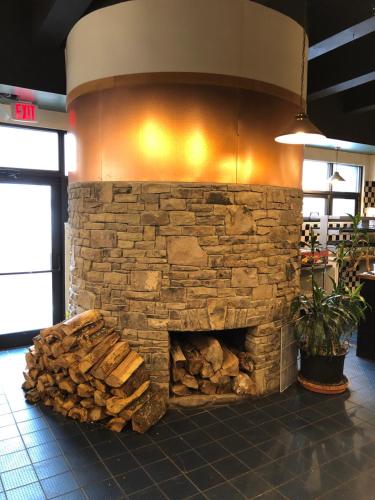 a stone fireplace in a restaurant with a pile of logs at Unique 2 Bed, 2 Bath with In & Out Night Skiing in Snowshoe
