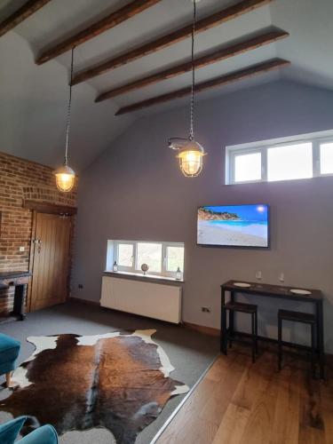 an empty living room with a table and windows at Two Bedroomed Loft Apartment - The Old Drill Hall Ryde in Ryde