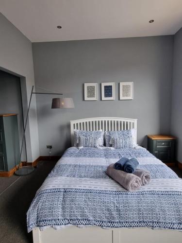 a bedroom with a large bed with a blue blanket at Two Bedroomed Loft Apartment - The Old Drill Hall Ryde in Ryde