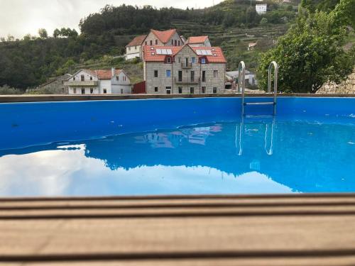 a reflection of a house in a swimming pool at Fândega House - Rural Tourism in Loriga