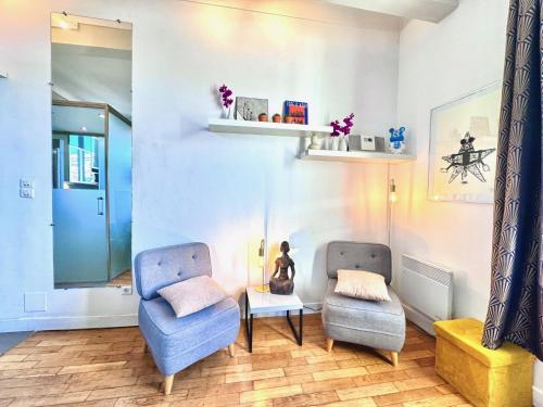 a living room with two chairs and a table at ApartHotel Riviera - LE COCON DE VICTOR - Grimaldi - Promenade des Anglais in Nice
