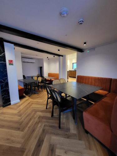a dining room with tables and chairs and a couch at Carlton Hotel in Sliema