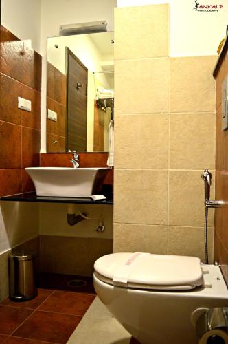 a bathroom with a toilet and a sink at Sepoy Grande Mysore in Mysore