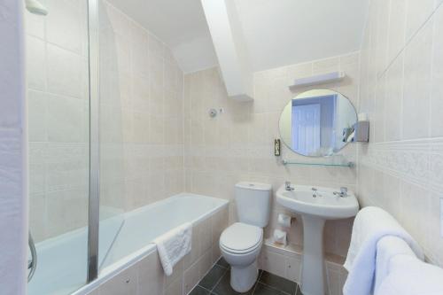 a white bathroom with a toilet and a sink at Appleby Manor Hotel & Garden Spa in Appleby