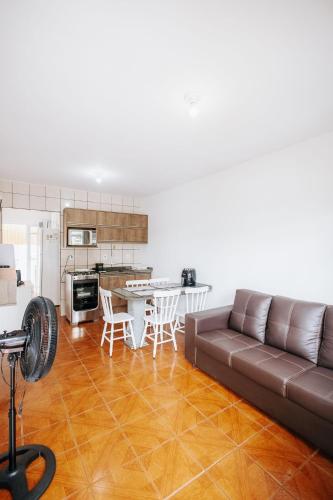 a living room with a couch and a kitchen at Residencial Mizinho Ap2 in Florianópolis