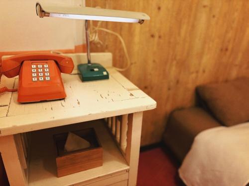 a table with a telephone on it with a couch at HOSTEL CHILLAX in Osaka