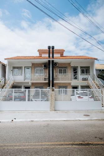 a house with a white fence in front of it at Residencial Mizinho Ap2 in Florianópolis