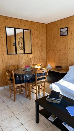 une salle avec une table et une salle à manger avec une horloge dans l'établissement Cottage 12B jusque 4 pers Bulle Der Lac du der, à Giffaumont